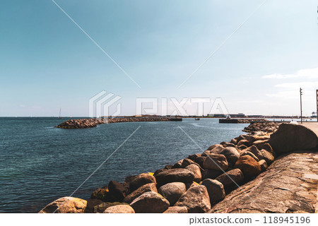 Seashore with big stones and breakwater in the distence. Seashore with big stones and breakwater in the distence. 118945196