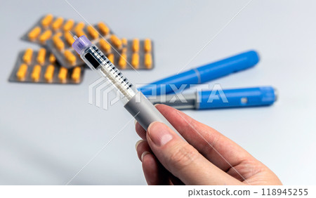 Hand holding Ozempic Insulin injection pen for diabetics and weight loss Hand holding Ozempic Insulin injection pen for diabetics and weight loss 118945255