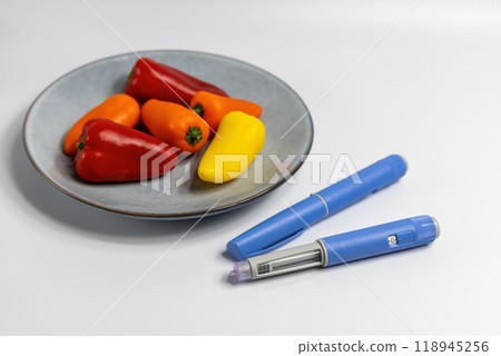 Ozempic Insulin injection pen for diabetics and weight loss on plate with vegetables 118945256