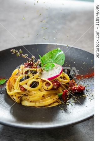 Spaghetti Carbonara with dried tomatoes and black olives Italian food 118946098