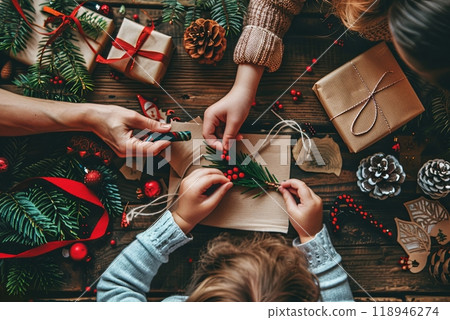 A child and parent craft a festive Christmas tree together, hands engaged in decorating. 118946274