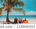 Sunny Seaside Retreat: African American couple lounging on sun loungers under palm tree on beautiful coastal beach. 118946303