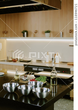 Vertical shot of modern kitchen counter with crockery and electronic devices on black top Vertical shot of modern kitchen counter with crockery and electronic devices on black top 118946721