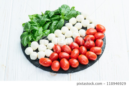 Basil leaves , cherry tomatoes and mozzarella cheese . In form italian flag food photography 118946929