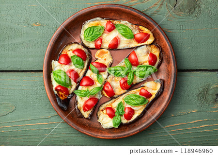 Italian mini pizza . Aubergine (eggplant ) with mozzarella cheese and basil . On rustic background Italian mini pizza . Aubergine (eggplant ) with mozzarella cheese and basil . On rustic background 118946960