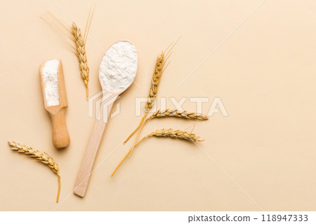 Flat lay of Wheat flour in wooden bowl with wheat spikelets on colored background. world wheat crisis 118947333
