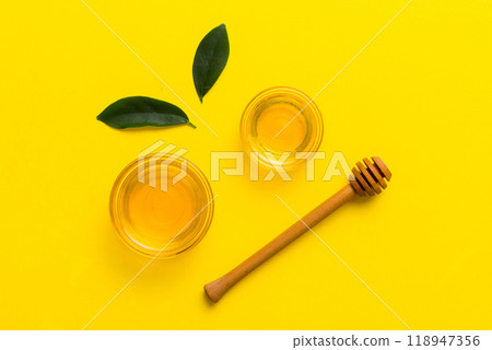 Honey jar with wooden honey dipper on white background top view with copy space. Delicious honey bottle 118947356