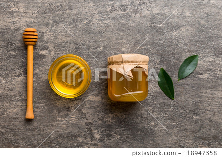 Honey jar with wooden honey dipper on white background top view with copy space. Delicious honey bottle 118947358