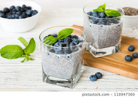 Healthy breakfast or morning with chia seeds vanilla pudding and blueberry berries on table background, vegetarian food, diet and health concept. Chia pudding with coconut milk and blueberry 118947360