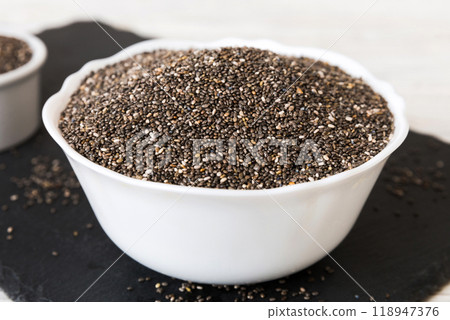 Chia seeds in bowl on colored background. Healthy Salvia hispanica in small bowl. Healthy superfood Chia seeds in bowl on colored background. Healthy Salvia hispanica in small bowl. Healthy superfood 118947376