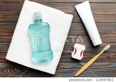 Mouthwash and other oral hygiene products on colored table top view with copy space. Flat lay. Dental hygiene. Oral care products and space for text on light background. concept Mouthwash and other oral hygiene products on colored table top view with copy space. Flat lay. Dental hygiene. Oral care products and space for text on light background. concept 118947661
