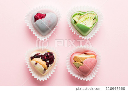 chocolate sweets in the form of a heart with fruits and nuts on a colored background. top view with space for text, holiday concept 118947668