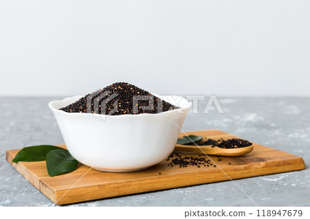 quinoa seeds in bowl and spoon on colored background. Healthy kinwa in small bowl. Healthy superfood quinoa seeds in bowl and spoon on colored background. Healthy kinwa in small bowl. Healthy superfood 118947679