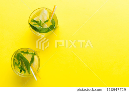 Caipirinha, Mojito cocktail, vodka or soda drink with lime, mint and straw on table background. Refreshing beverage with mint and lime in glass top view flat lay Caipirinha, Mojito cocktail, vodka or soda drink with lime, mint and straw on table background. Refreshing beverage with mint and lime in glass top view flat lay 118947729
