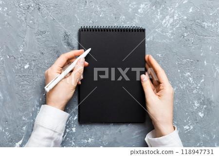 Woman hand with pencil writing on notebook. Woman working on office table. Female hand holding pencil and sketchbook. Mock-up Concept Woman hand with pencil writing on notebook. Woman working on office table. Female hand holding pencil and sketchbook. Mock-up Concept 118947731