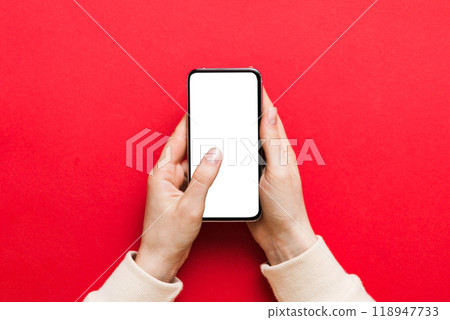 Top view of woman hands holding smart phone with blank copy space screen for your text message or information content. woman hand using phone white screen on top view Top view of woman hands holding smart phone with blank copy space screen for your text message or information content. woman hand using phone white screen on top view 118947733
