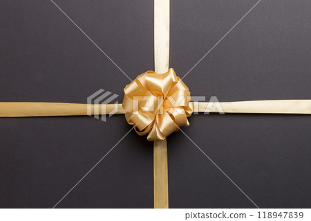Top view of gold ribbon rolled and yellow bow isolated on colored background. Flat lay with copy space Top view of gold ribbon rolled and yellow bow isolated on colored background. Flat lay with copy space 118947839