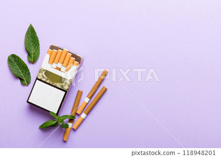 Pack of menthol cigarettes and fresh mint on colored table, Menthol cigarettes top view flat lay Pack of menthol cigarettes and fresh mint on colored table, Menthol cigarettes top view flat lay 118948201