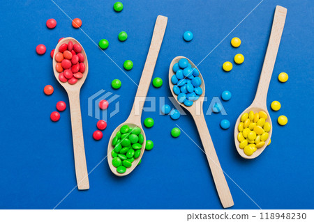 delicious colorful sweet candies on spoon on colored background . Confectionery decor top view with copy space delicious colorful sweet candies on spoon on colored background . Confectionery decor top view with copy space 118948230