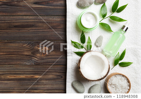 Coconut with jars of coconut oil and cosmetic cream on colored background. Top view. Free space for your text. Natural spa coconut cosmetics and organic treatment concept Coconut Spa composition 118948308