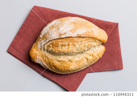 Freshly baked delicious french bread with napkin on rustic table top view. Healthy white bread loaf 118948321