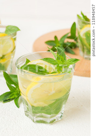 Mojito cocktail. Refreshing mojito cocktail with lime, lemon and mint in a tall glass with a stick Mojito cocktail. Refreshing mojito cocktail with lime, lemon and mint in a tall glass with a stick 118948457