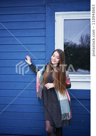 portrait of a young woman with long blond hair in a light dress in winter by blue barn portrait of a young woman with long blond hair in a light dress in winter by blue barn 118948663