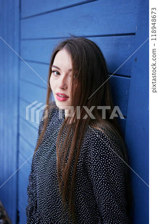 portrait of a young woman with long blond hair in a light dress in winter by blue barn portrait of a young woman with long blond hair in a light dress in winter by blue barn 118948673