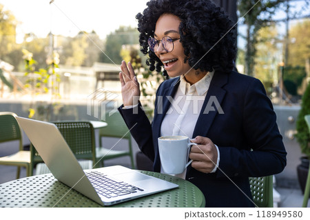 Business woman sitting in a cafe and having a video call Business woman sitting in a cafe and having a video call 118949580