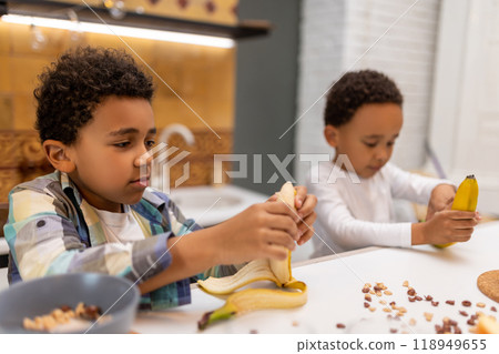 Two siblings sitting at the table and having breakfast 118949655