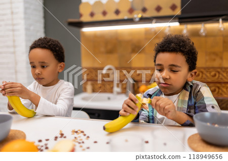 Two siblings sitting at the table and having breakfast Two siblings sitting at the table and having breakfast 118949656