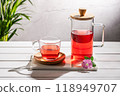 Red fruit infusion in crystal glass and pitcher on withe wooden base. 118949707