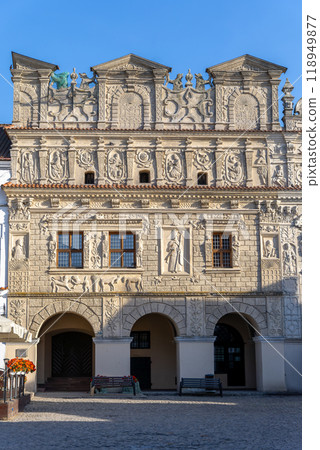 A close up of the intricately detailed facade of the Przybyo House in Kazimierz Dolny, Poland. This Renaissance building showcases rich architectural carvings and historical motifs against a vibrant b 118949877