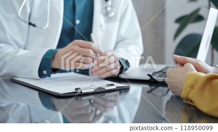 Doctor and patient consultation in clinic. Patient listens attentively as a doctor explains a diagnosis in a modern medical office. Medicine and health care 118950099