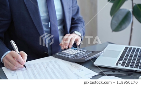 Businessman analyzing financial data on laptop and calculator. Close-up of a professional auditor working on financial reports. Business concept 118950170