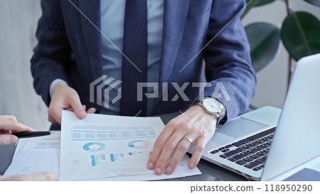 Two professionals analyzing a pie chart during a strategic business meeting. Business meeting with graph analysis Two professionals analyzing a pie chart during a strategic business meeting. Business meeting with graph analysis 118950290