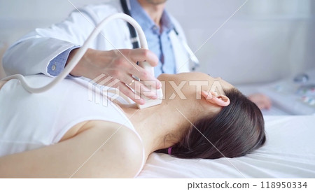 Doctor man is using ultrasound equipment on neck of female patient lying down for a medical examination. Medicine and science 118950334