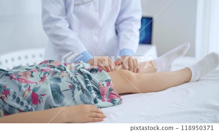 Doctor and kid patient. Orthopedist examining girl's knee in medical clinic. Medicine and health care Doctor and kid patient. Orthopedist examining girl's knee in medical clinic. Medicine and health care 118950371