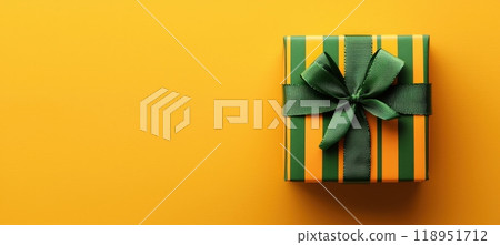 Cheerful Gift Box with Green Ribbon on Yellow Background - Perfect for Summer Themed Designs 118951712
