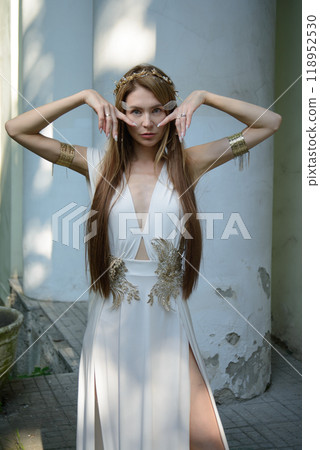Two beautiful girls, sisters Lilith and Eva, pose in rocking dresses against the background of columns. 118952530
