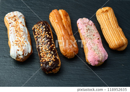 Assorted eclairs on a pastel top view Traditional French dessert Assorted eclairs on a pastel top view Traditional French dessert 118952635