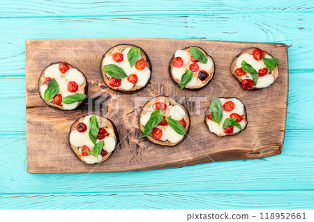 Italian mini pizza . Aubergine (eggplant ) with mozzarella cheese and basil . On rustic background 118952661