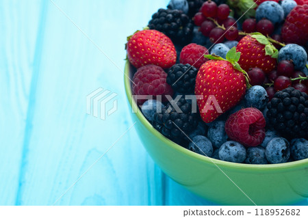 Mix of ripe colorful berries in bowl photography . Blueberry , strawberry , raspberry , blackberry and red currant . Top view 118952682