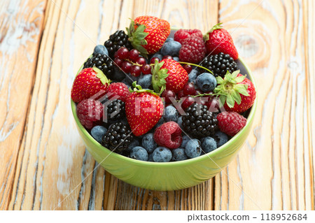 Mix of ripe colorful berries in bowl photography . Blueberry , strawberry , raspberry , blackberry and red currant . Top view 118952684