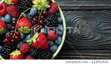 Mix of ripe colorful berries in bowl photography . Blueberry , strawberry , raspberry , blackberry and red currant . Top view 118952685