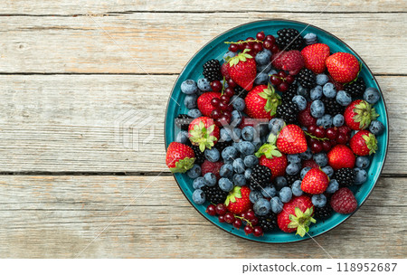 Mix of ripe colorful berries in bowl photography . Blueberry , strawberry , raspberry , blackberry and red currant . Top view 118952687