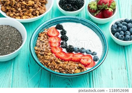 Healthy breakfast . Yogurt with berries ( strawberry , raspberry , blueberry , blackberry ) , granola and chia seeds . Top view 118952696