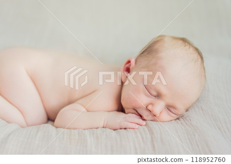 The baby is sleeping peacefully in his cozy nest. Newborn photo session captures the serene innocence and warmth of early moments 118952760