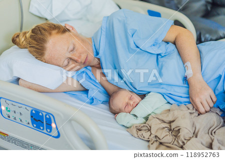 A baby lies with the mother after childbirth, resting peacefully. The serene moment captures the bond between mother and child as they begin their journey together. The hospital environment ensures a A baby lies with the mother after childbirth, resting peacefully. The serene moment captures the bond between mother and child as they begin their journey together. The hospital environment ensures a 118952763