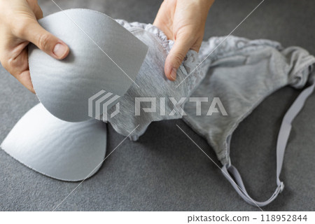 Woman puts the pads in a bra for extra size. Woman puts the pads in a bra for extra size. 118952844